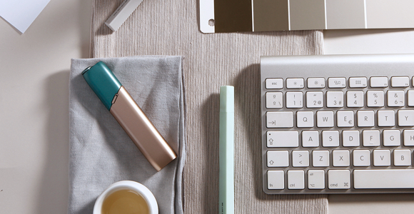 Green and coppery IQOS 3 MULTI kit on a working desk