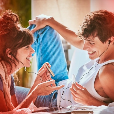 Una mujer sosteniendo un dispositivo IQOS sonrie a su pareja