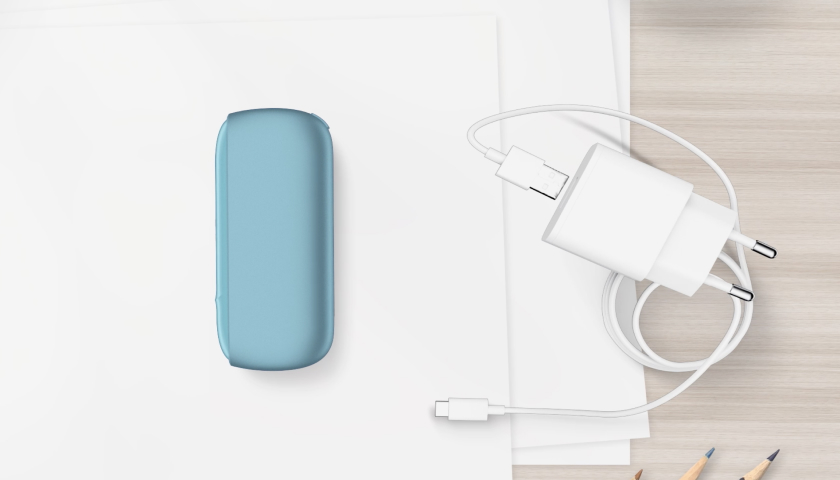 IQOS Originals Duo turquesa al lado del cargador.