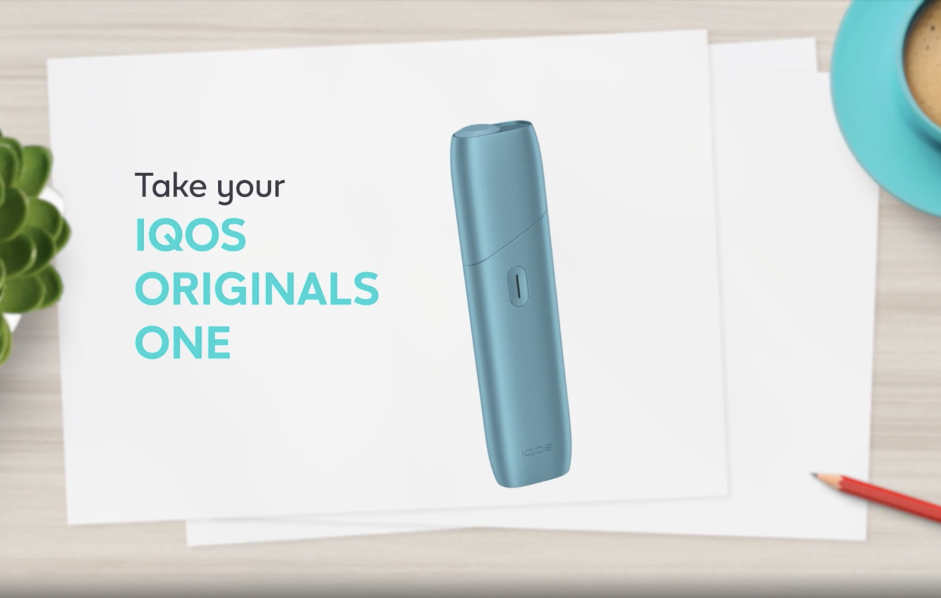 IQOS Originals One turquesa al lado del cargador.