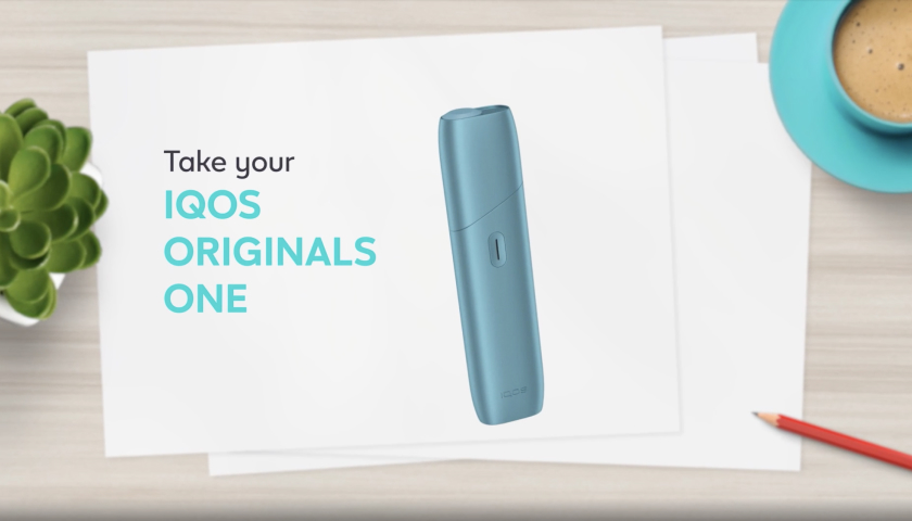 IQOS Originals One turquesa al lado del cargador.