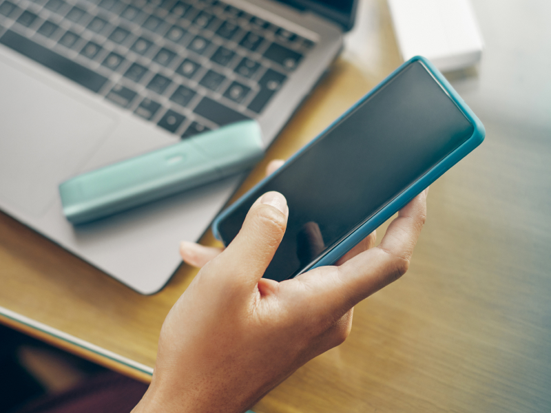 Manos sosteniendo un celular, actualizando el dispositivo IQOS Originals One.