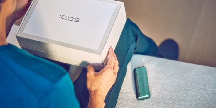 Manos destapando un dispositvo IQOS