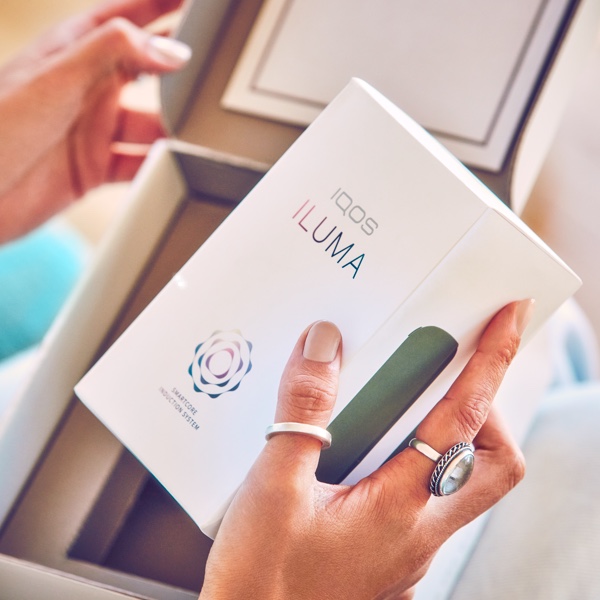 Persona sosteniendo una caja de IQOS ILUMA
