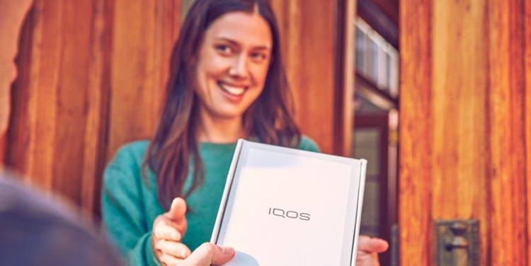 Persona recibe una caja de IQOS
