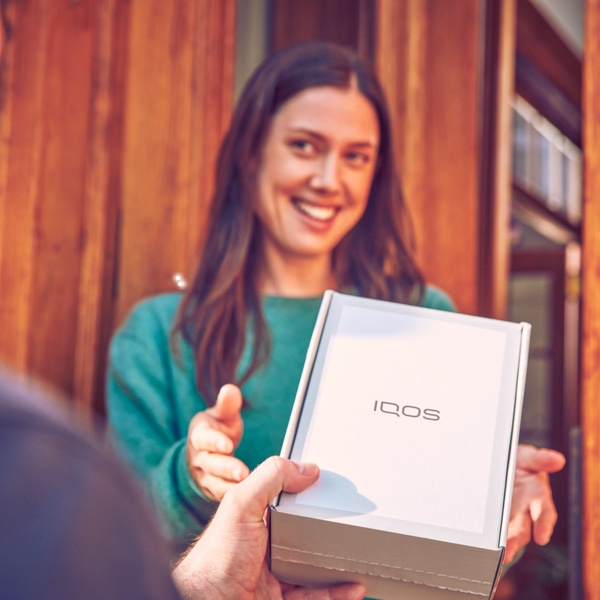 Persona recibe una caja de IQOS