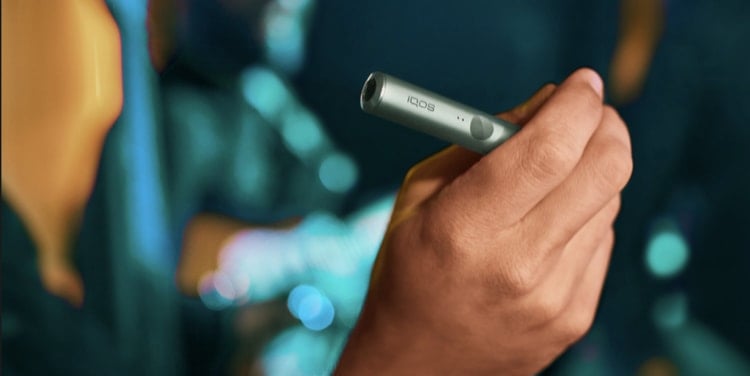 Manos sosteniendo un IQOS ILUMA PRIME verde