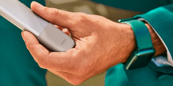 Manos destapando un dispositvo IQOS
