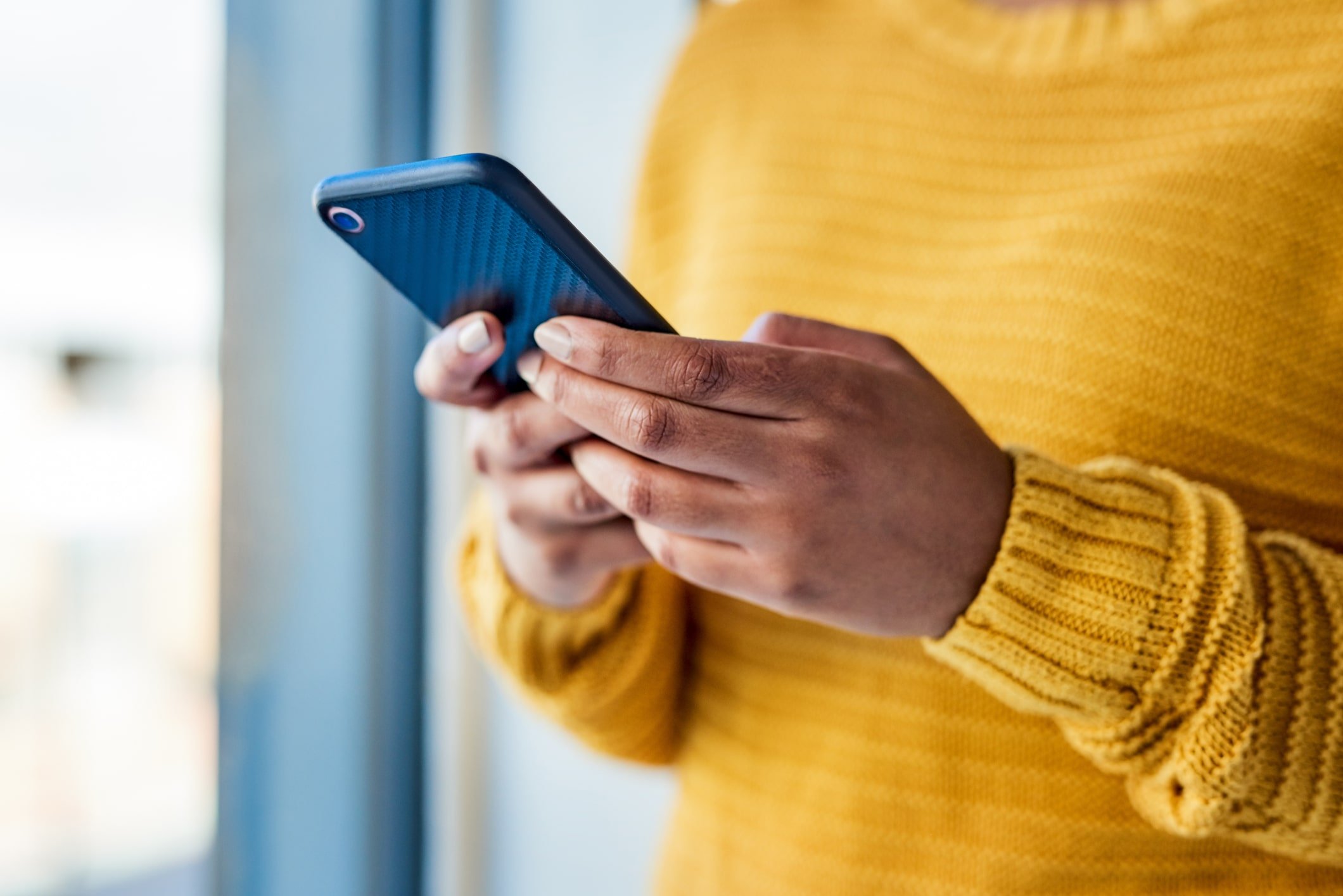 Persona sosteniendo un celular en sus manos