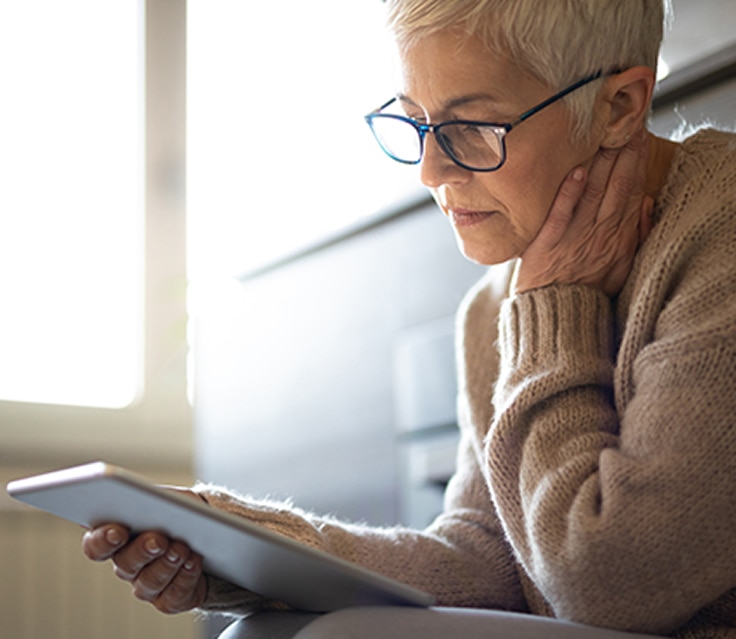 Mujer con gafas sosteniendo un Ipad.